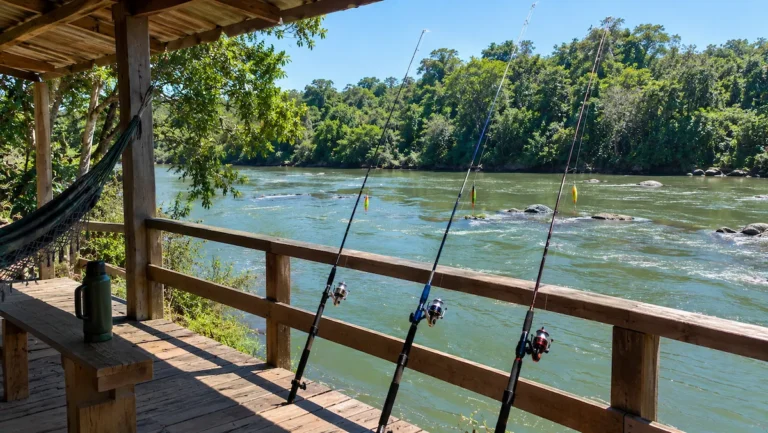 Varanda de rancho de pesca à beira de rio com varas e iscas artificiais prontas para o dourado
