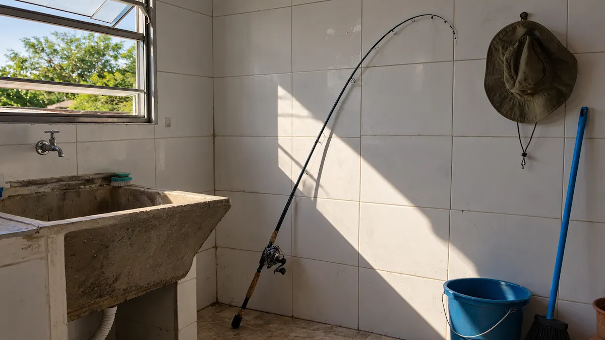 Como guardar vara de pesca: vara encostada no canto da área de serviço com a ponteira envergada e sol batendo na vara